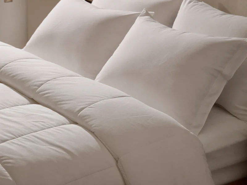 Couette matelassée et deux oreillers en taies blanches sur un lit